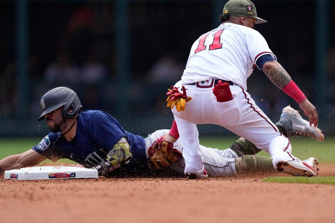 Seattle Mariners’ Jose Caballero (76) beats the tag from Atlanta Braves shortstop Orlando Arcia (11) as he steals second base in the sixth inning of a baseball game, Sunday, May 21, 2023, in Atlanta. (AP Photo/John Bazemore)