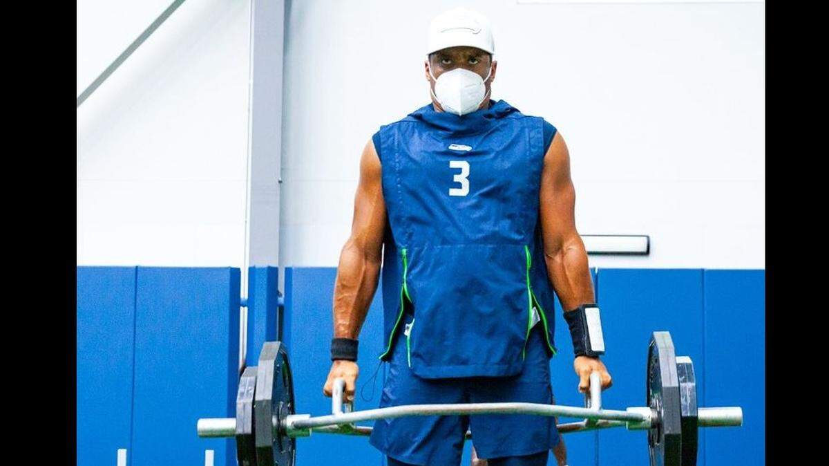 Quarterback Russell Wilson lifts weights on the Seahawks’ indoor practice field at team headquarters in Renton during training camp this past weekend. Gov. Jay Inslee applauded the Seahawks for training while wearing masks during the coronavirus pandemic.