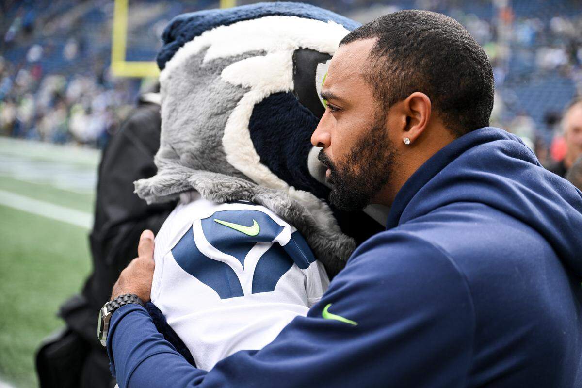 Doug Baldwin, wide receiver on the Super Bowl champion Seahawks, hugs Blitz before the game between the Seattle Seahawks and the Carolina Panthers at Lumen Field, Sunday, Sept. 24, 2023, Seattle, Wash.