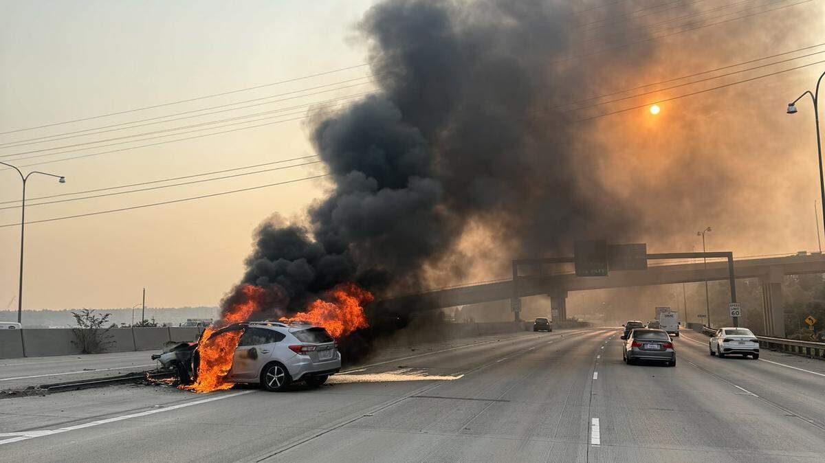 A car burst into flames on I-5 near the Tacoma Dome after it struck a barrier.