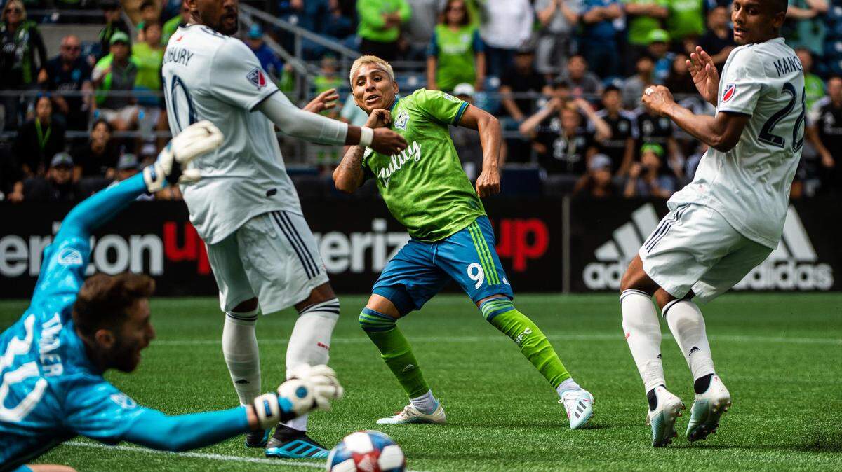 New England Revolution goalkeeper Matt Turner (30) blocks a shot by Seattle Sounders forward Raul Ruidiaz (9) in the final minutes of the second half. The Seattle Sounders played the New England Revolution in a major league soccer match at CenturyLink Field in Seattle, Wash., on Saturday, Aug. 10, 2019.