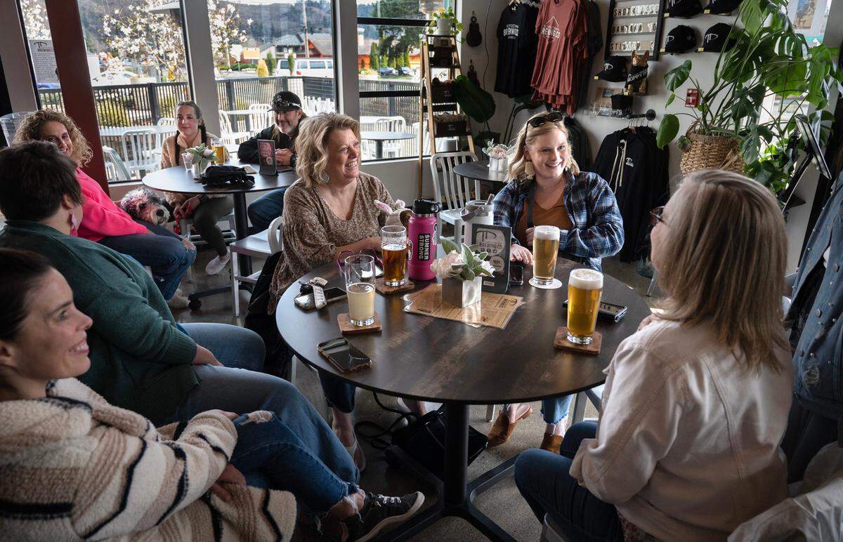 Susie Burd (from left), Elaine Smith, Kelsie Cornett and Lorie Cornett gather at Top Down Brewering Co. in Sumner, Washington, on Wednesday, April 5, 2023.