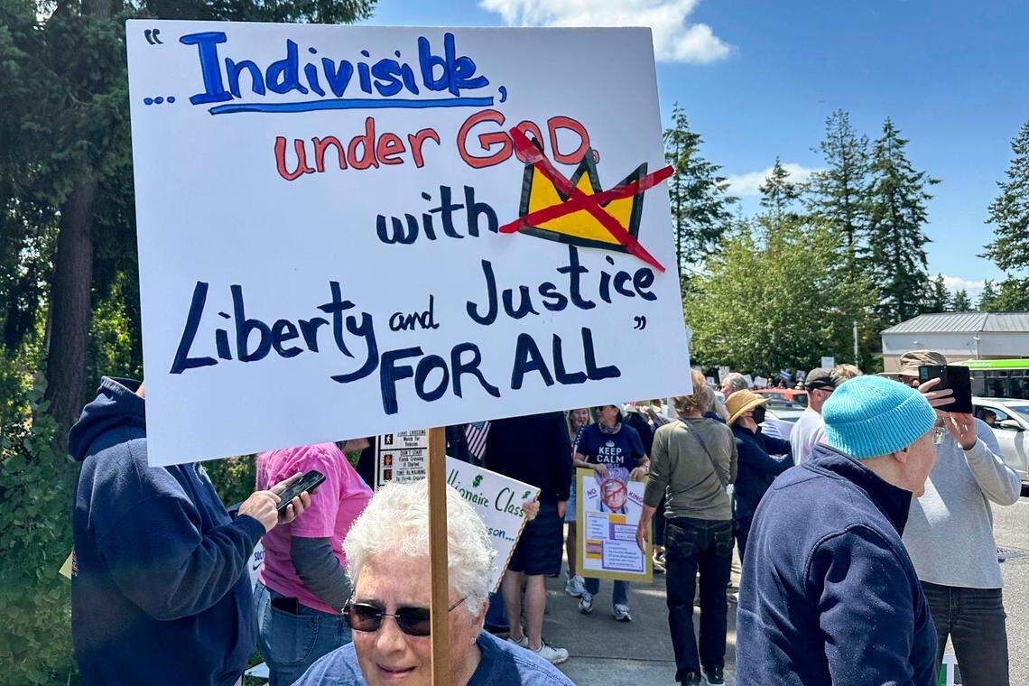 Demonstrators gathered at the corner of Point Fosdick Drive & Olympic Drive in Gig Harbor, Wash., on Saturday, June 14, 2025, for the No Kings rally.