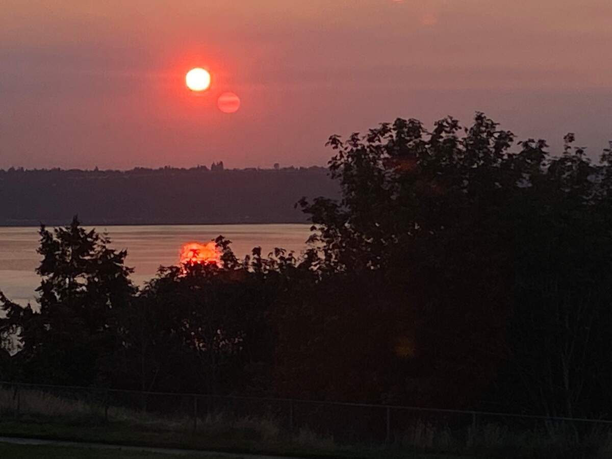 The sun rises over Commencement Bay in Tacoma, Washington, through a haze of wildfire smoke Friday, Sept. 9, 2022.