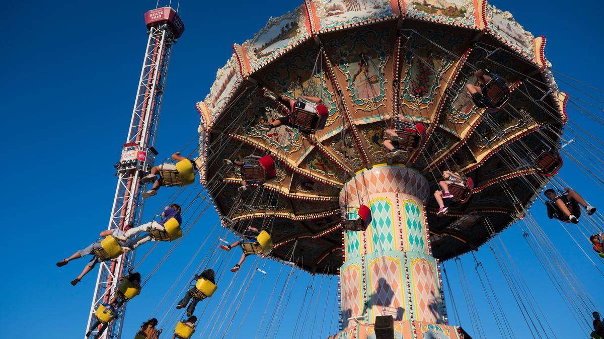 The Extreme Scream is lifted as fairgoers ride the Wave Swinger during the opening day of the Washington State Fair, on Friday, Aug. 30, 2024, in Puyallup, Wash.