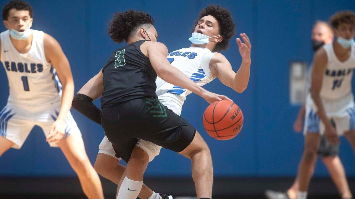 Auburn’s Maleek Arington bowls over Federal Way’s Marcus Cole during the Tigers’ 55-53 win over the Eagles in the 3A/4A NPSL boys basketball crossover championship game at Federal Way High School in Federal Way, Washington, on Saturday, June 26, 2021.