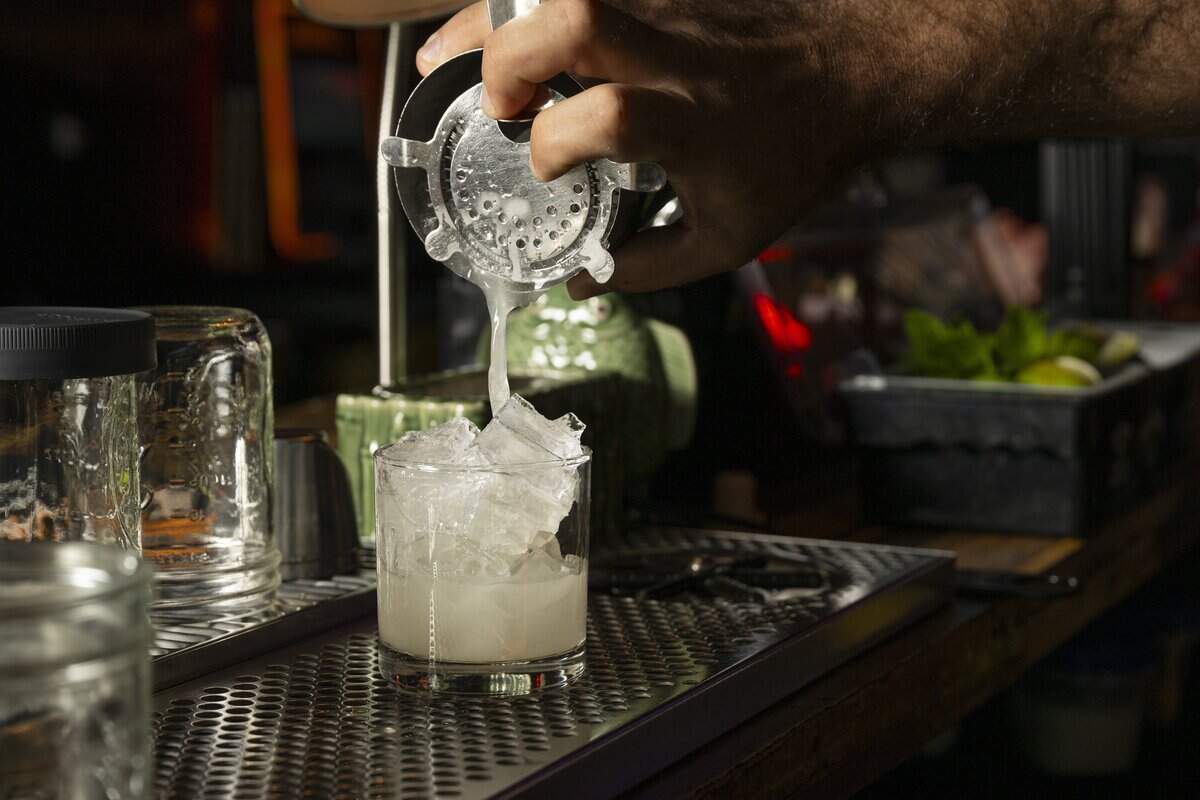 Sam Halhuli, owner of The Mule Tavern, pours a shaken Paper Tiger at the dive bar on Wednesday, July 8, 2026, in Tacoma, Wash.