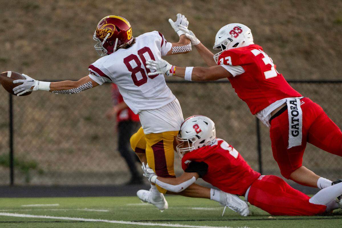 After catching a pass from quarterback Gunnar Trachte, Enumclaw’s Karson Holt (80) dives into the endzone for a touchdown as Steilacoom’s Noah Maxwell (2) and Deidrick McCrayton (33) attempt to tackle him during the first quarter of a 2A SPSL game on Friday, Sept. 15, 2023, in Steilacoom, Wash.
