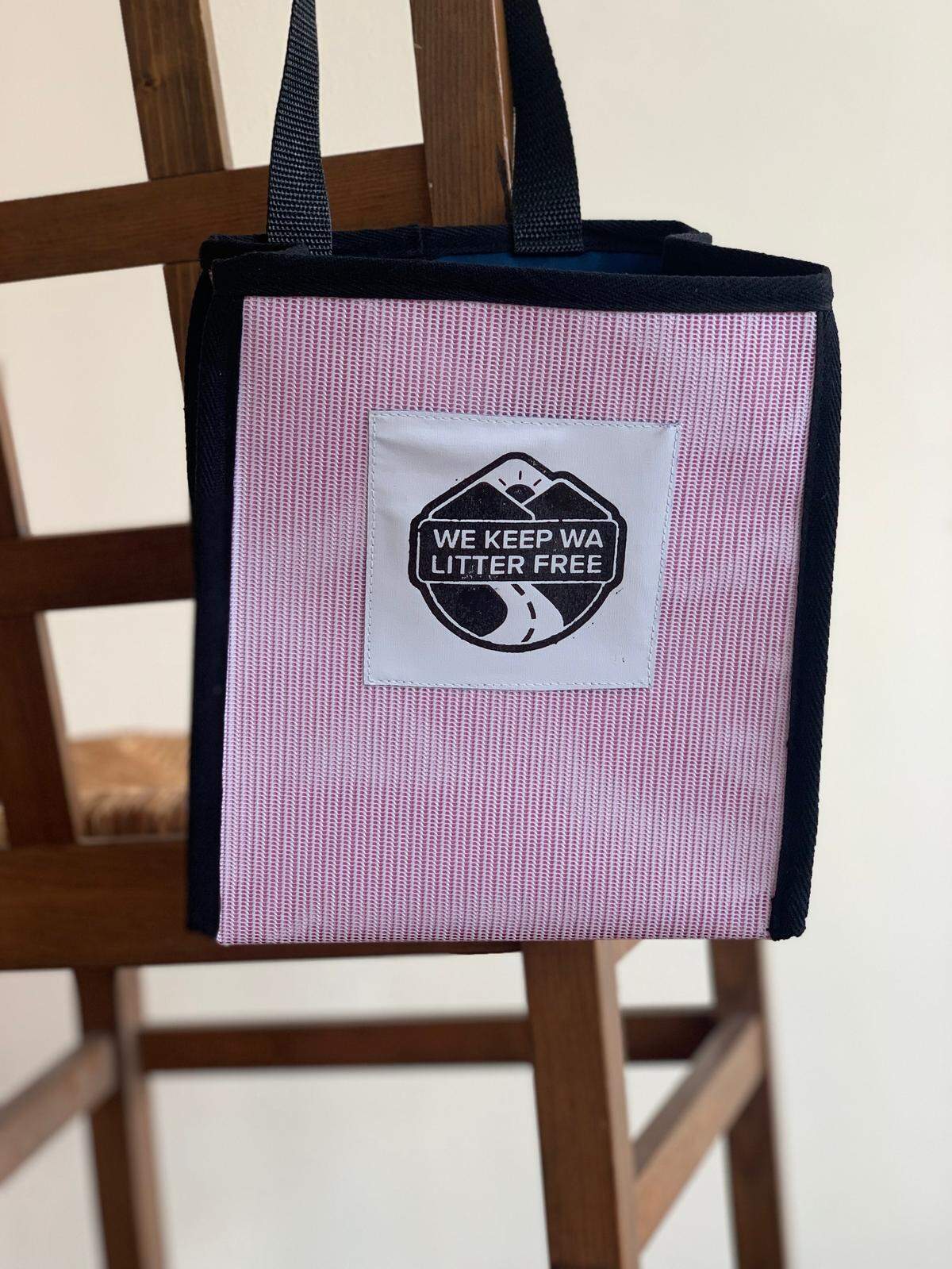 A litter bag created from upcycled material hangs from a chair. The bags are handmade by immigrant and refugee women employed with Refugee Artisan Initiative.