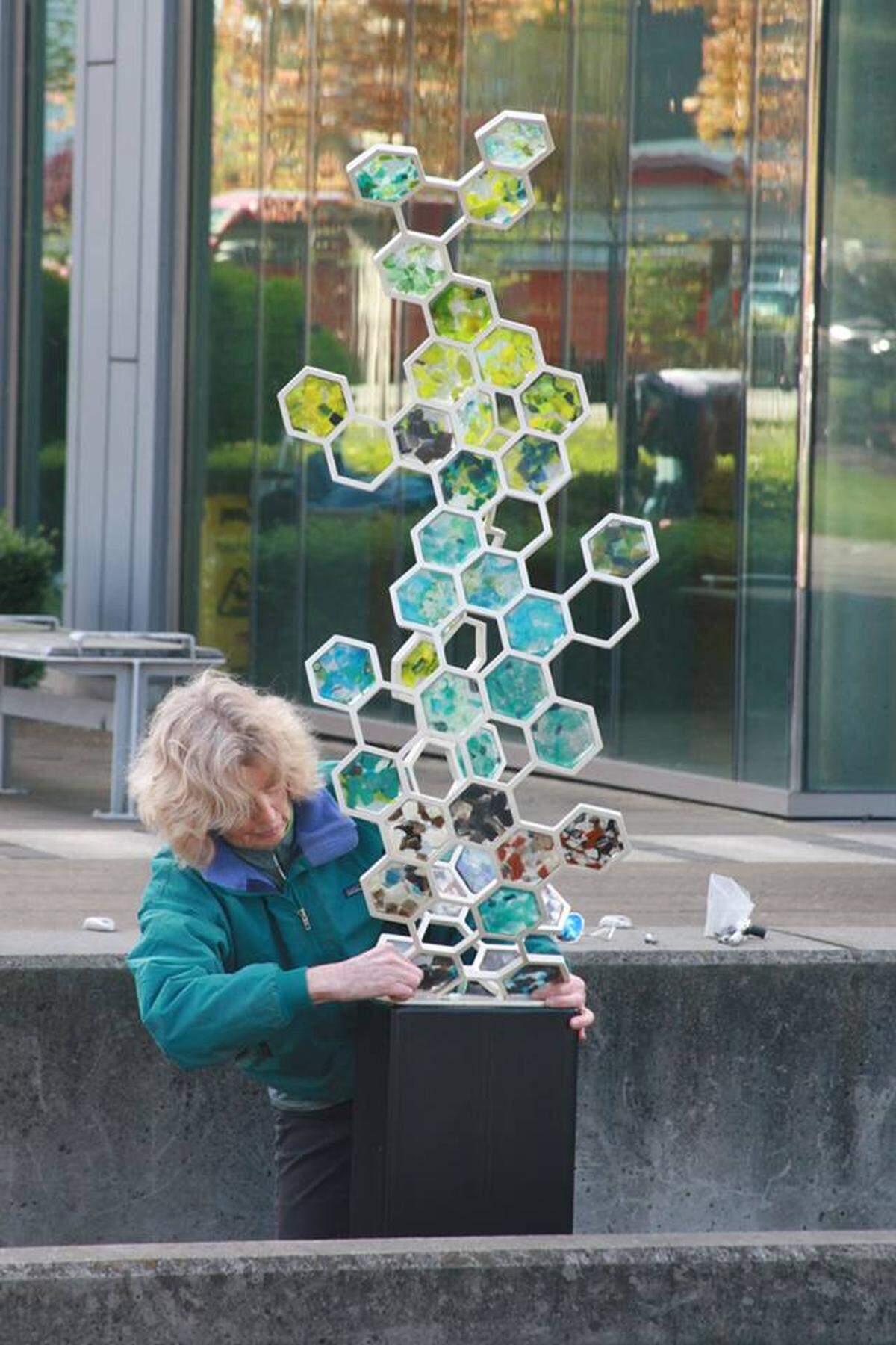 “Fossil Ill” is a reminder of the important role bees play in the environment, according to artists Lin McJunkin and Milo White. The sculpture replicates nature with glass hexagons of aquamarine and spring greens fitted in metal forms. The hexagons resemble a honeycomb.