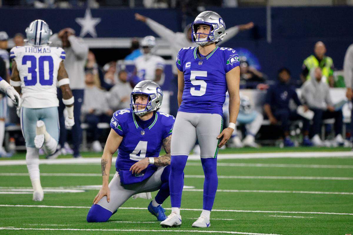 Seattle Seahawks’ Michael Dickson (4) and place kicker Jason Myers (5) look on at Myers missed field goal attempt as Dallas Cowboys’ Juanyeh Thomas (30) runs off the field in the first half of an NFL football game in Arlington, Texas, Thursday, Nov. 30, 2023. (AP Photo/Michael Ainsworth)