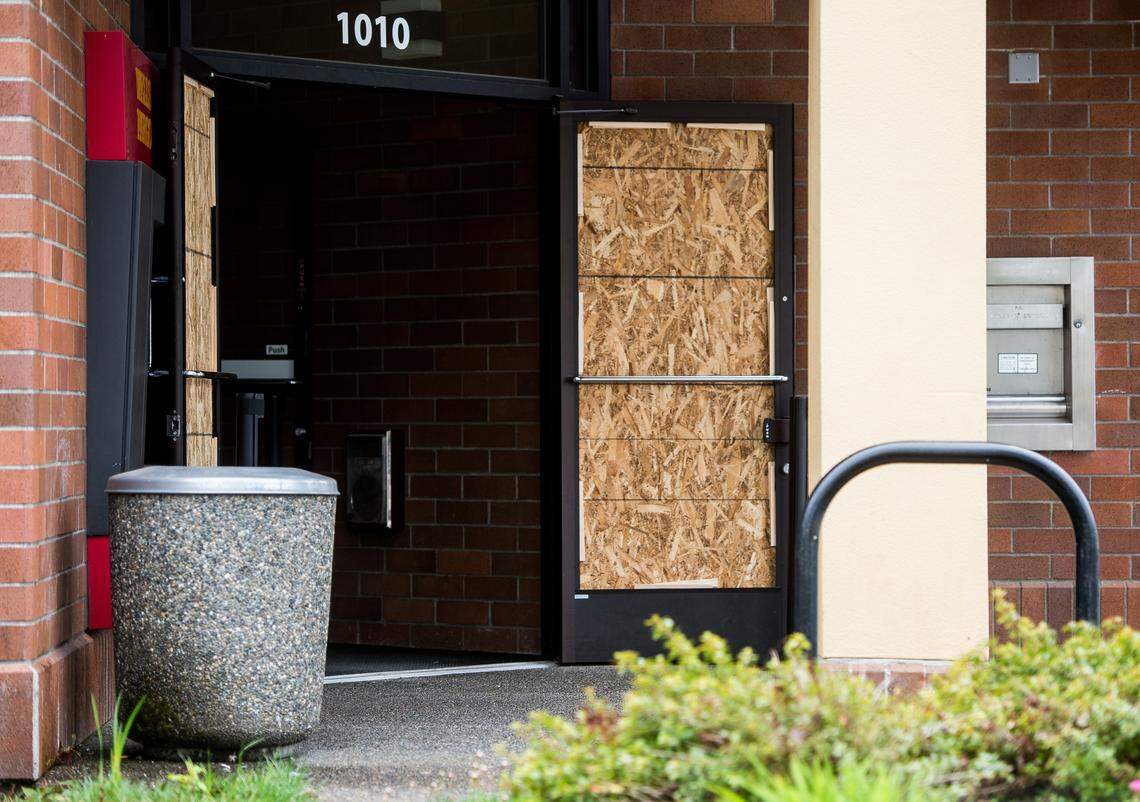 Wood panels cover broken doors at the Wells Fargo bank branch in Lacey, Wash. on Tuesday, May 1, 2018. 