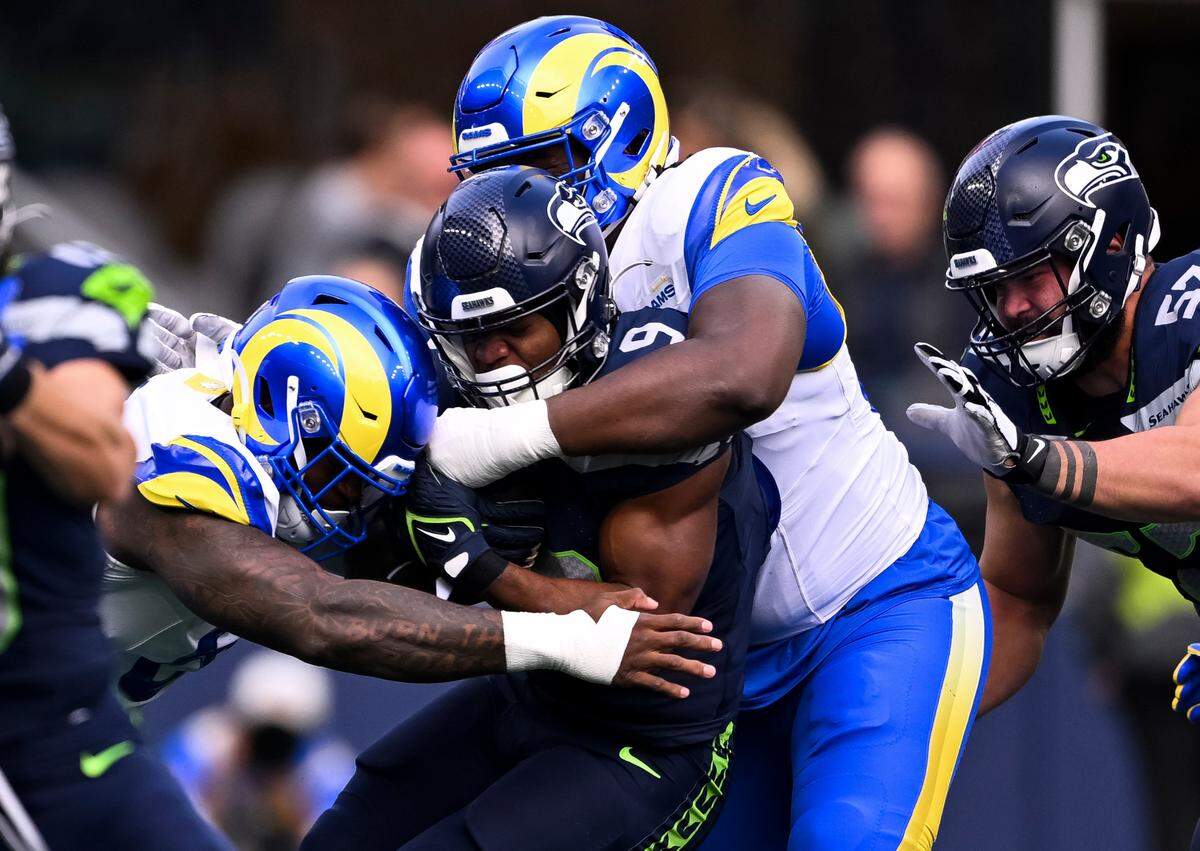 Los Angeles Rams defensive tackle Bobby Brown III (95) wraps up Seattle Seahawks running back Kenneth Walker III (9) during the first quarter of the game at Lumen Field, on Sunday, Nov. 3, 2024 in Seattle, Wash.