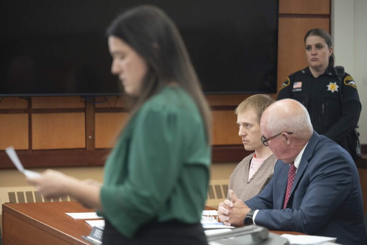 Jordan Henderson, center, listens as his wife Katie Henderson speaks to the judge during his sentencing on Friday, May 8, 2026, at Pierce County Superior Court in Tacoma, Wash. Henderson, 36, was convicted by a jury of 12 counts of first-degree child molestation in January.