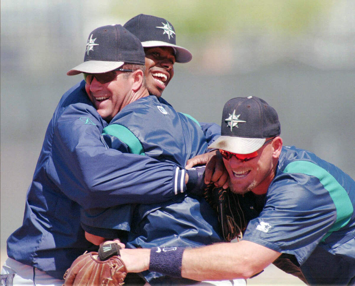 Seattle Mariners Ken Griffey Jr., rear, and Jay Buhner, right, tease a ticklish Edgar Martinez following a team batting practice Monday, March 24, 1997 in Peoria, Ariz. The Mariners are thinking about the possibility of going to their first World Series this season. ‘I think it’s our best team,’ Martinez said. (AP Photo/Elaine Thompson)