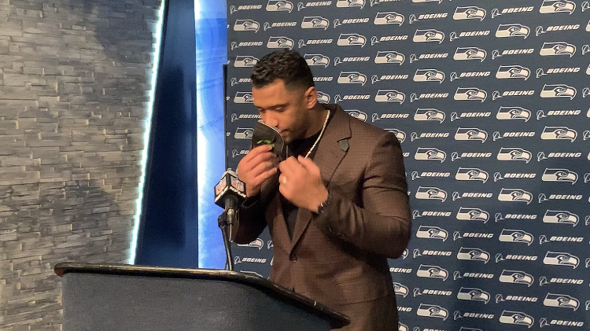 Quarterback Russell Wilson removes his face mask before he begins a postgame press conference in Houston following the Seahawks’ 33-13 victory over the Texans on Sunday, Dec. 12, 2021, at NRG Stadium.