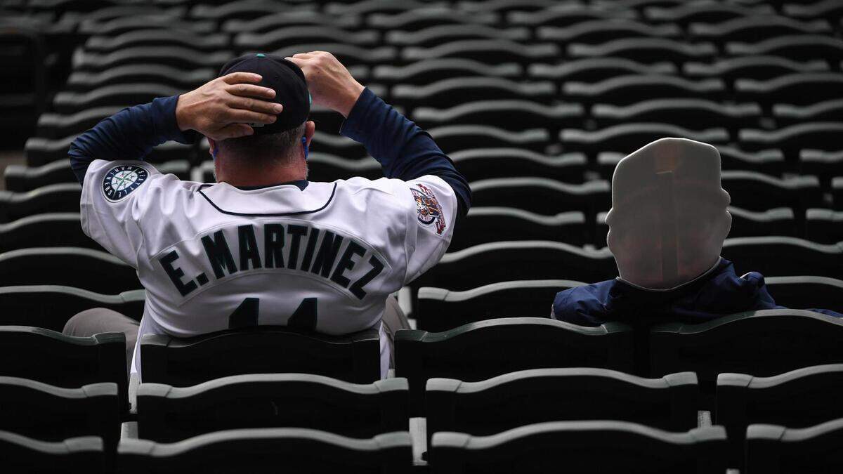 Kevin Cannon sits next to a cutout of his friend during the game. The Seattle Mariners played the San Francisco Giants in a Major League Baseball game at T-Mobile Park in Seattle, Wash., on Thursday, April 1, 2021.