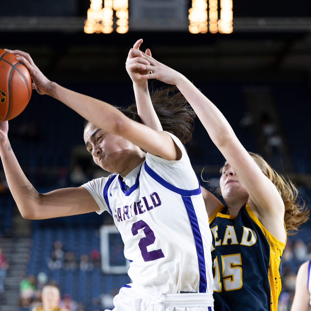 Garfield’s Katie Fiso (2) snags a defensive rebound over Mead’s Ellie Thornton (15) during the Class 3A state championship game at the Tacoma Dome, on Saturday, March 2, 2024, in Tacoma, Wash.