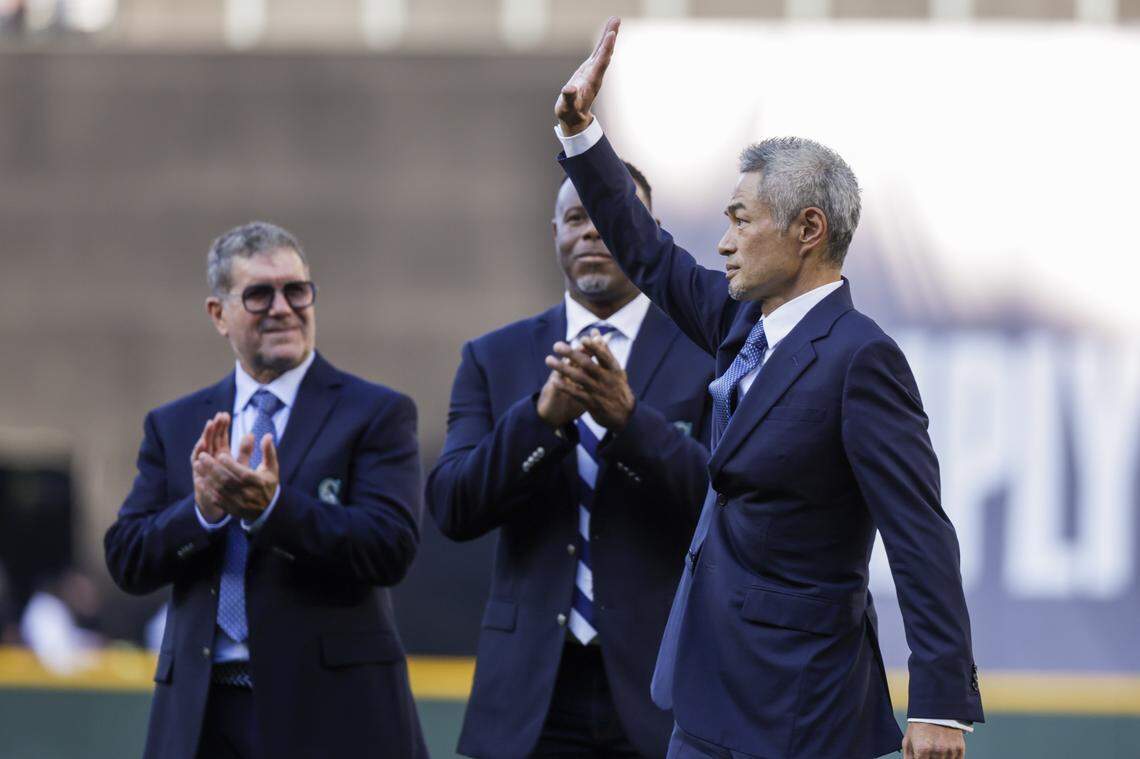 Aug 9, 2025; Seattle, Washington, USA; Seattle Mariners former outfielder Ichiro Suzuki, right, waves to fans following a ceremony to retire his number before a game against the Tampa Bay Rays at T-Mobile Park. Seattle Mariners former outfielder Ken Griffey, Jr., middle, and hitting coach Edgar Martinez, left stand behind Suzuki. Mandatory Credit: Joe Nicholson-Imagn Images