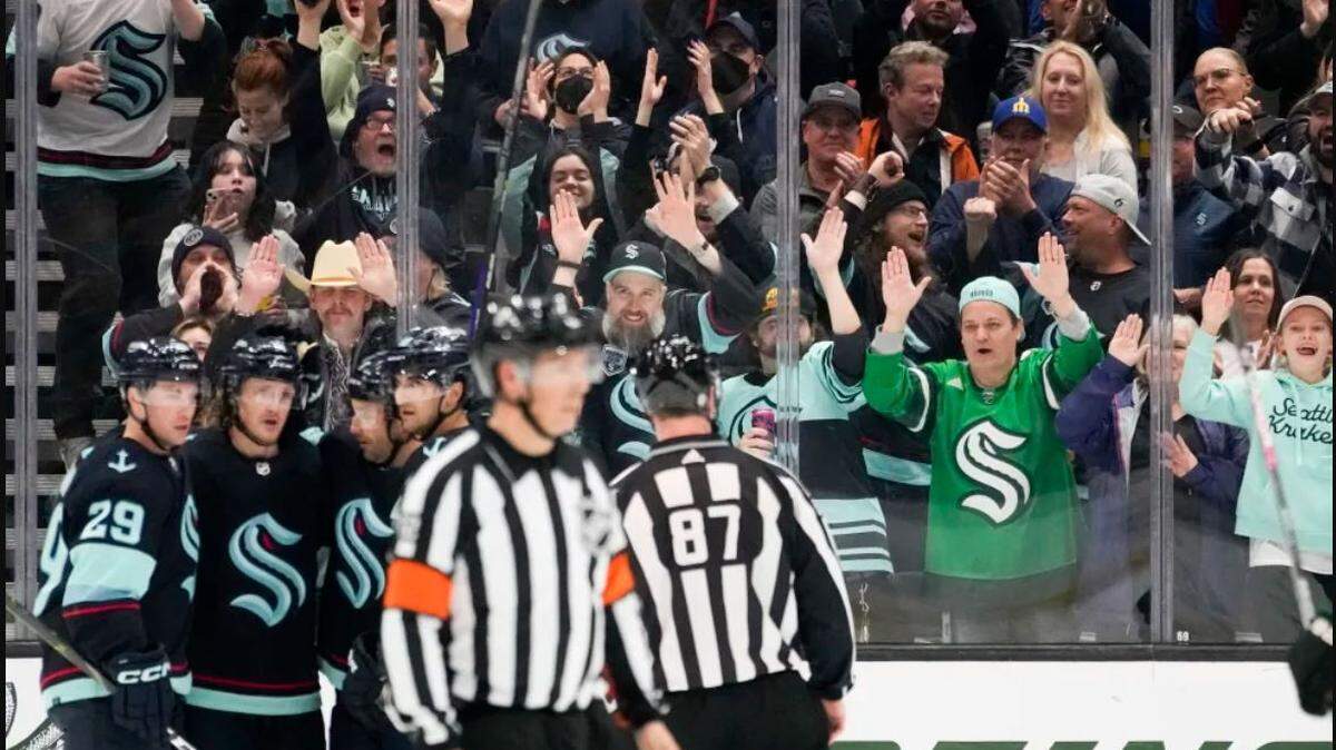 Seattle Kraken fans pound the glass as they celebrate a goal by right wing Jordan Eberle against the Arizona Coyotes during the second period of an NHL hockey game Thursday, April 6, 2023, at Climate Pledge Arena. The Kraken clinched the first Stanley Cup Playoffs berth in team history.