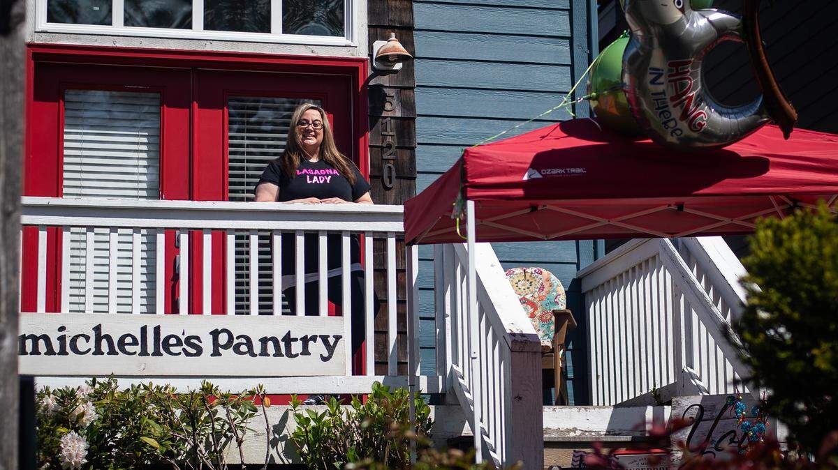 Michelle Brenner stands for a portrait outside her home in Gig Harbor, Wash., on Thursday, April 30, 2020. After being furloughed due to the pandemic, Brenner began making lasagna for health care workers and anyone in the community that could use a hot meal. People can order lasagnas online and pick up them up at a booth she set up outside her house.