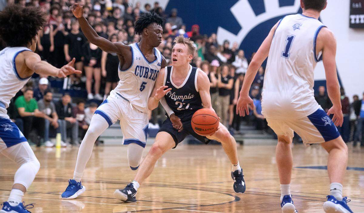 Olympia’s Parker Gerrits squares off against Curtis’ Zoom Dialo during Saturday night’s 4A SPSL boys basketball tournament championship game at Tacoma Community College in Tacoma, Washington, on Feb. 4, 2023.