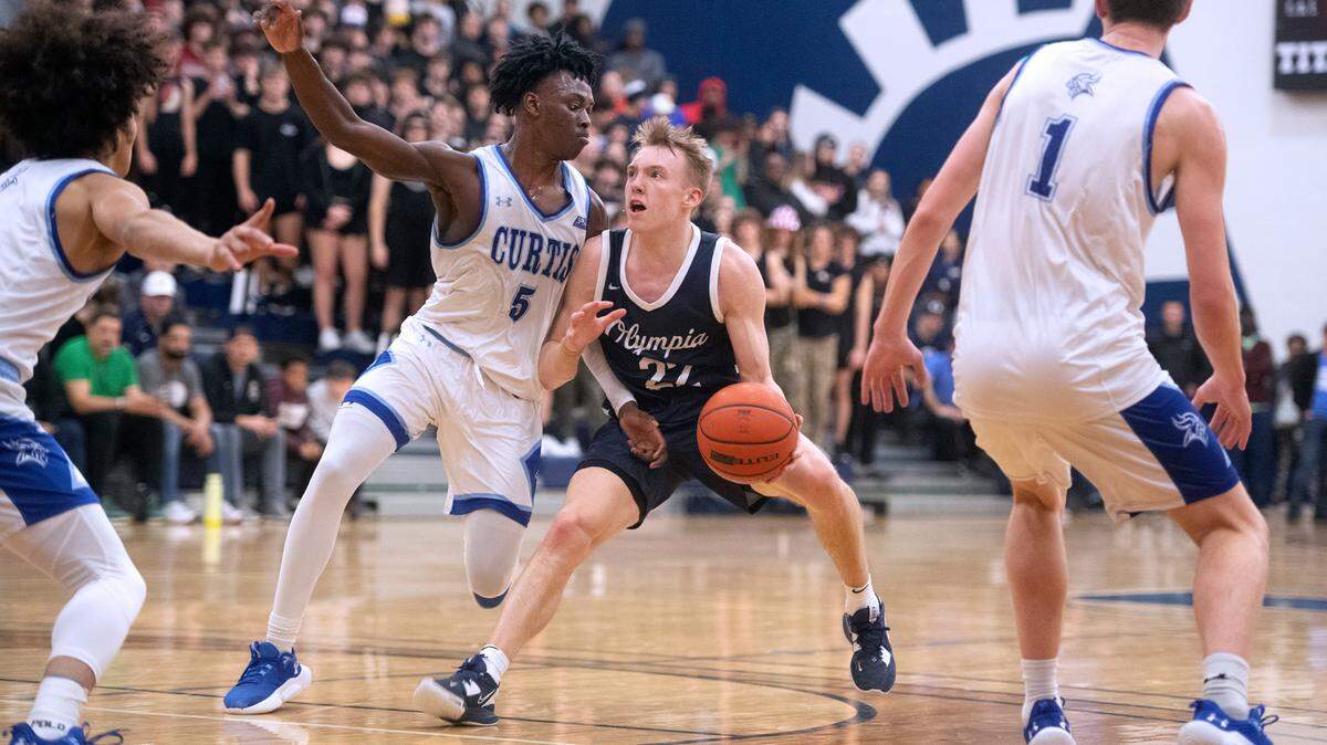 Olympia’s Parker Gerrits squares off against Curtis’ Zoom Dialo during Saturday night’s 4A SPSL boys basketball tournament championship game at Tacoma Community College in Tacoma, Washington, on Feb. 4, 2023.