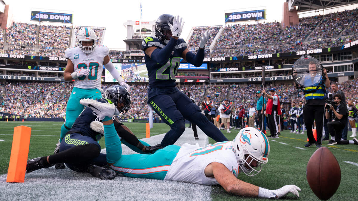 Miami Dolphins tight end Durham Smythe (81) falls short on a touchdown pass under coverage from Seattle Seahawks safety Rayshawn Jenkins (2) and safety Julian Love (20) during the fourth quarter of the game at Lumen Field, on Sunday, Sept. 22, 2024, in Seattle, Wash.