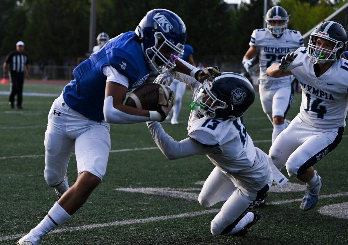 Mataio Wilson (2) stiff arms Olympia’s Canon Betts (13) after a reception during the first half of the high school football game at Curtis Senior High School, Thursday, Aug. 31, 2023, University Place, Wash.