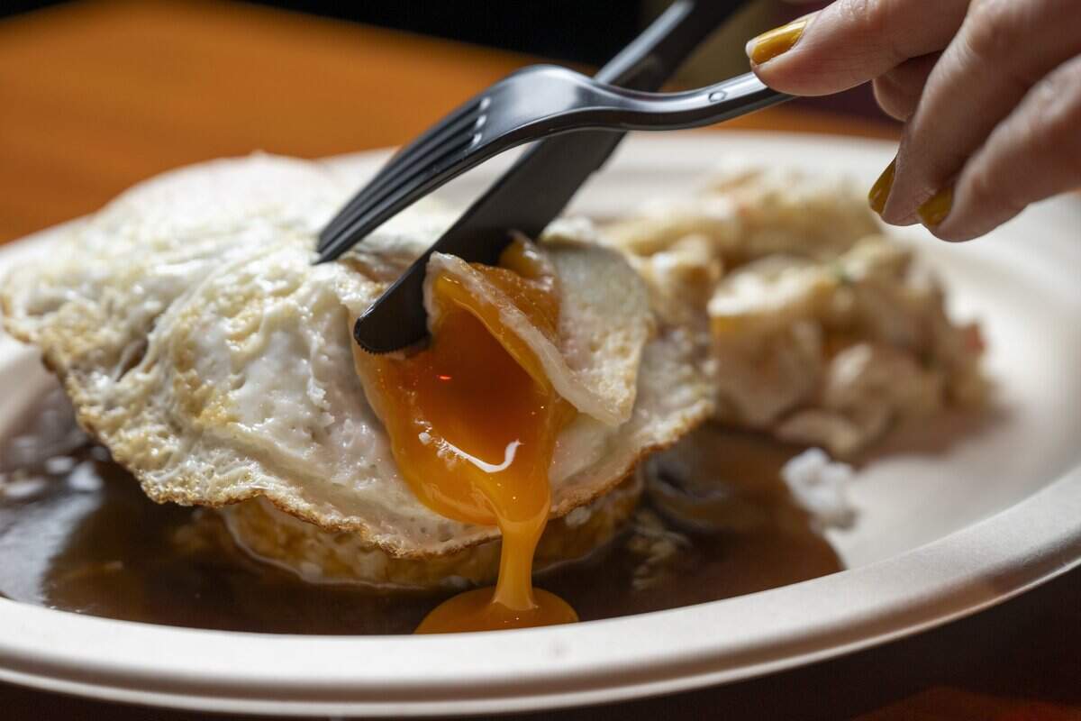 Fried egg yolk spills over a Loco Moco at Da Tiki Hut on Thursday, July 9, 2026, at Da Tiki Hut in Tacoma, Wash.
