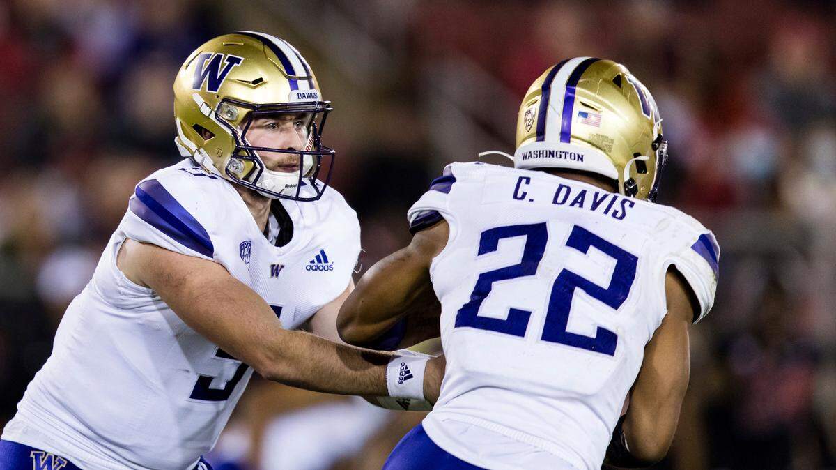 Washington quarterback Dylan Morris (9) hands off toe running back Cameron Davis (22) against Stanford during the third quarter of an NCAA college football game in Stanford, Calif., Saturday, Oct. 30, 2021. Washington won 20-13. (AP Photo/John Hefti)