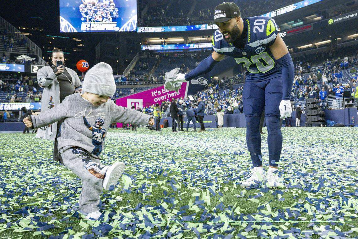 Seattle Seahawks safety Julian Love (20) and his son, front, play in the confetti left on the field after the Seahawks beat the Rams in the NFC Championship game at Lumen Field, on Sunday, Jan. 25, 2026, in Seattle.