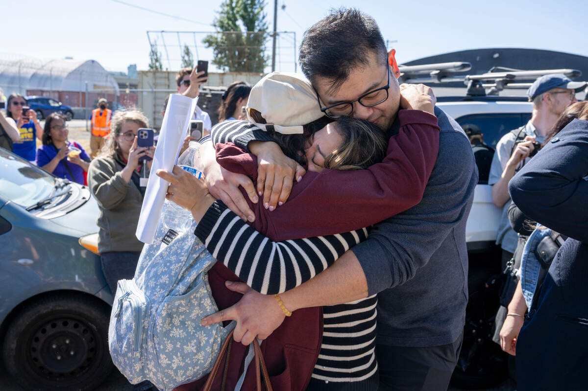 Lewelyn Dixon, left, is wrapped into a hug by loved ones after Dixon’s released from the Northwest ICE Processing Center on Thursday, May 29, 2025, where she has been detained for months in Tacoma, Wash.