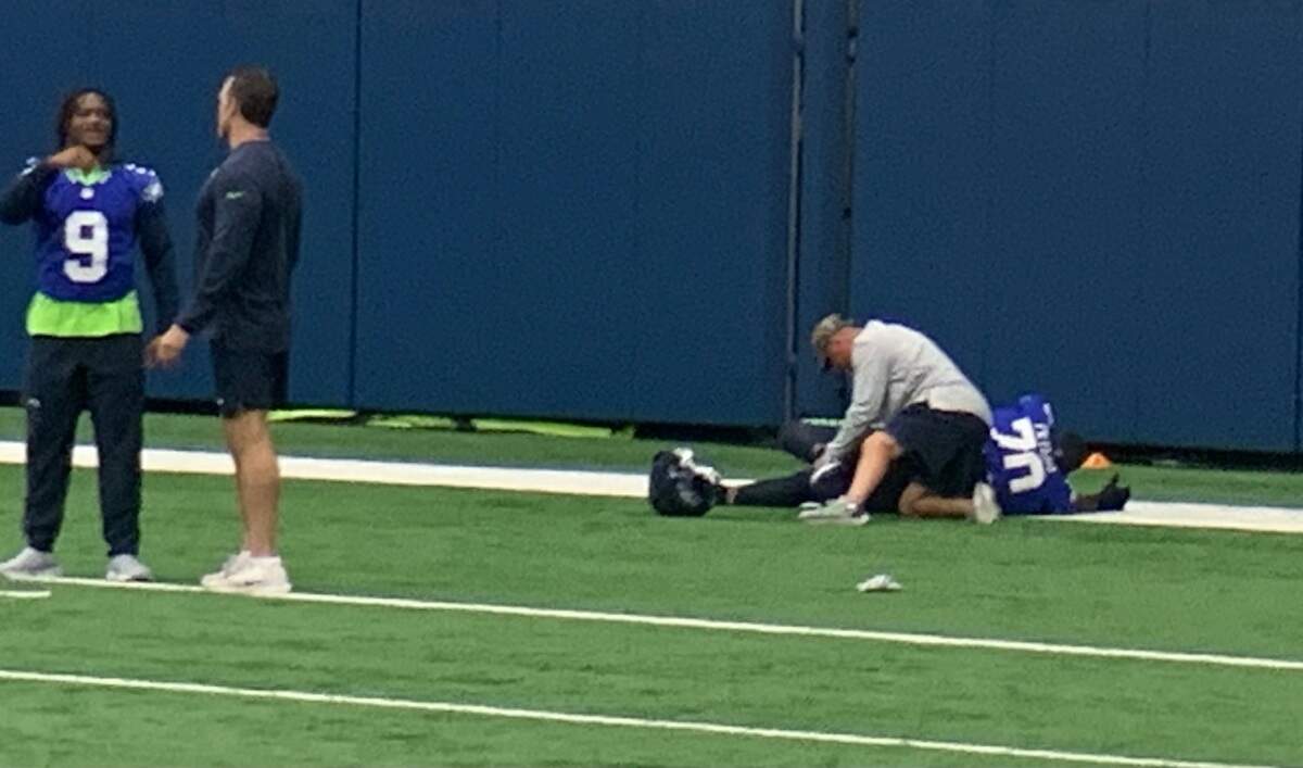 With running back Kenneth Walker (9) nearby, Jason Peters with a trainer doing his usual leg stretches with a band at the start of Seahawks practice Oct. 25, 2023. The 41-year-old three-time All-Pro left tackle signed with Seattle’s practice squad Sept. 12.