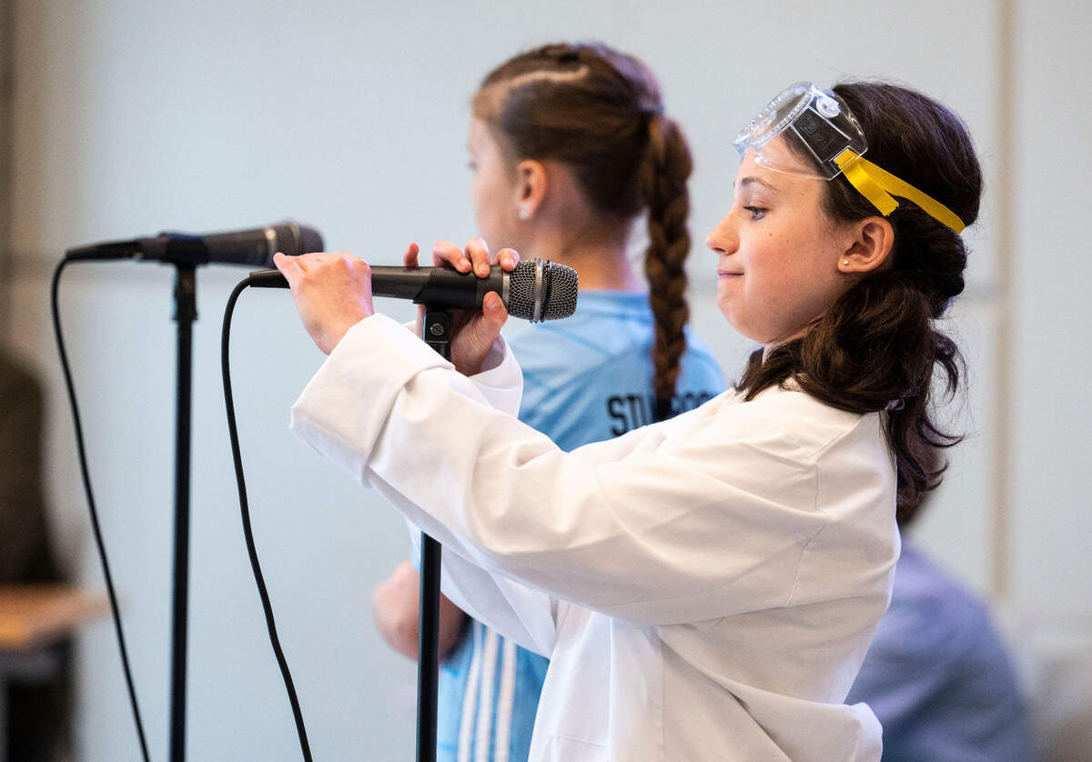 Pioneer Elementary student Sydney A. adjusts her microphone as she and her partner, Piper S., present their invention called “Magnet Soccer Ball” to their peers while competing in the 2023 3D Print & Design “Shark Tank” Competition at the school in Gig Harbor, Wash. on May 5, 2023.