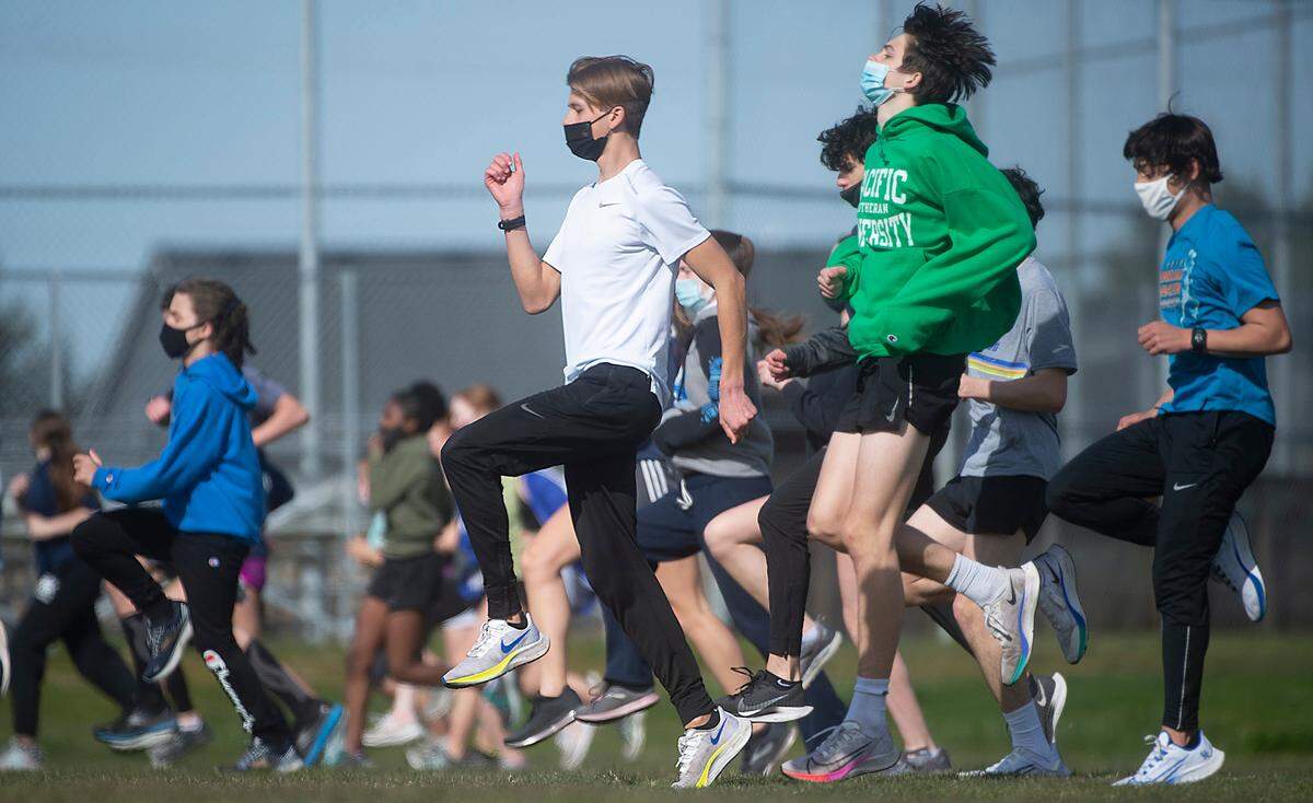 Lakes High School sophomore cross country runner Cruize Corvin warms up with teammates at Lakes High School in Lakewood, Washington, on Tuesday, March 16, 2021.. Cruize has the top time in Pierce County this spring and one of the top time’s in the state.