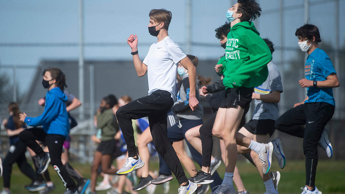 Lakes High School sophomore cross country runner Cruize Corvin warms up with teammates at Lakes High School in Lakewood, Washington, on Tuesday, March 16, 2021.. Cruize has the top time in Pierce County this spring and one of the top time’s in the state.