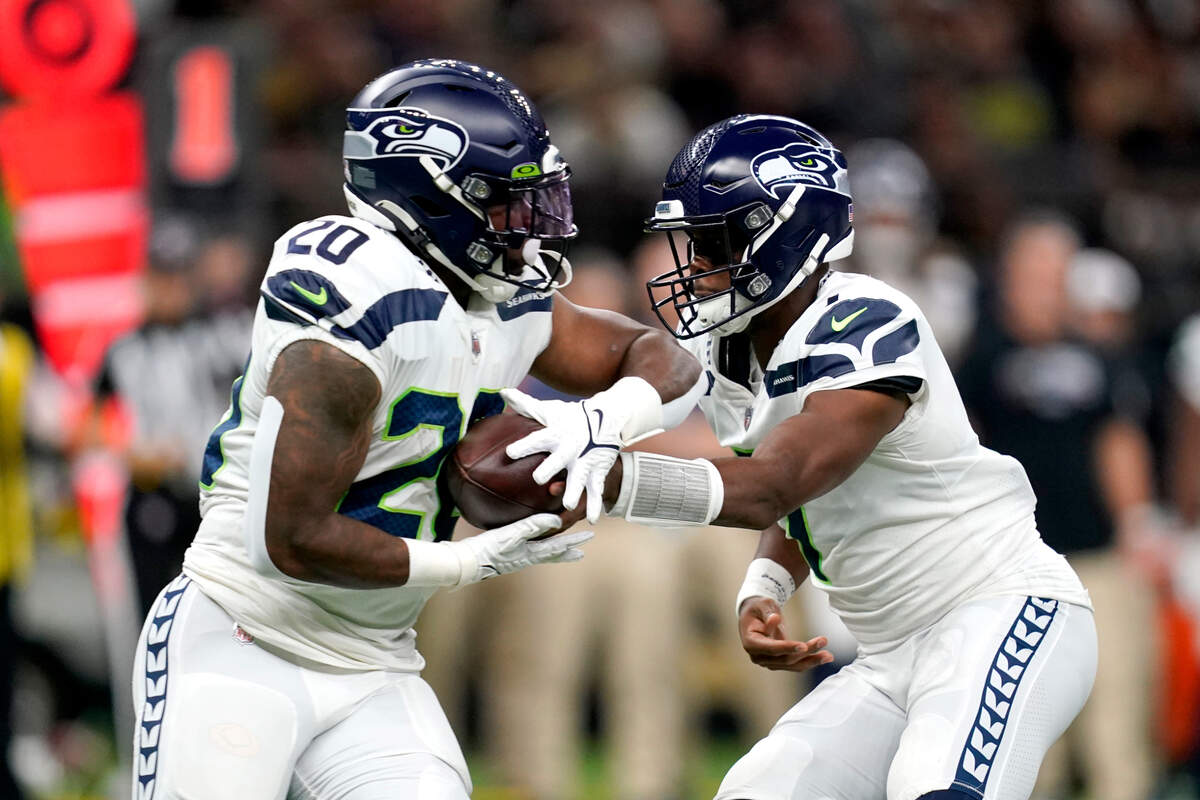 Seattle Seahawks quarterback Geno Smith, right, hands off to running back Rashaad Penny during an NFL football game against the New Orleans Saints in New Orleans, Sunday, Oct. 9, 2022. (AP Photo/Gerald Herbert)