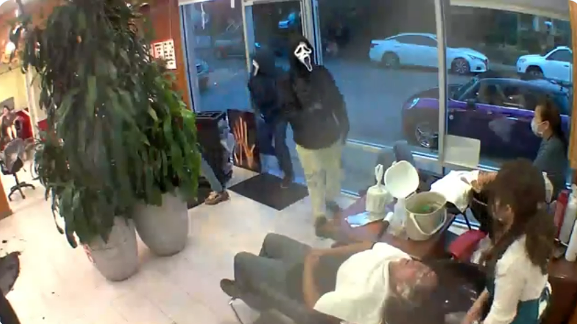 Three people wearing “Scream” face masks are shown on video surveillance entering a Seattle hair salon. They are accused of robbing customers and the business on Oct. 17, 2021.