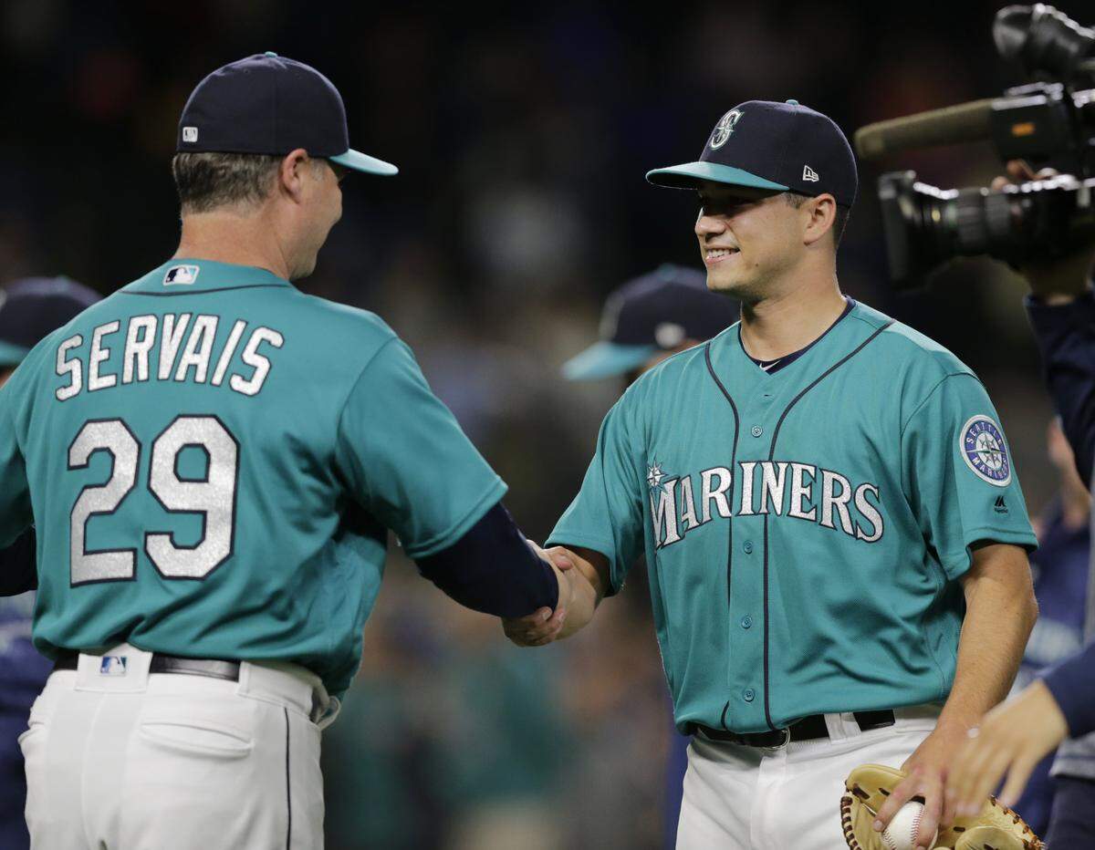 Seattle Mariners manager Scott Servais , left, congratulates starting pitcher Marco Gonzales after pitching a complete baseball game for a win against the Kansas City Royals, Friday, June 29, 2018, in Seattle. (AP Photo/John Froschauer)