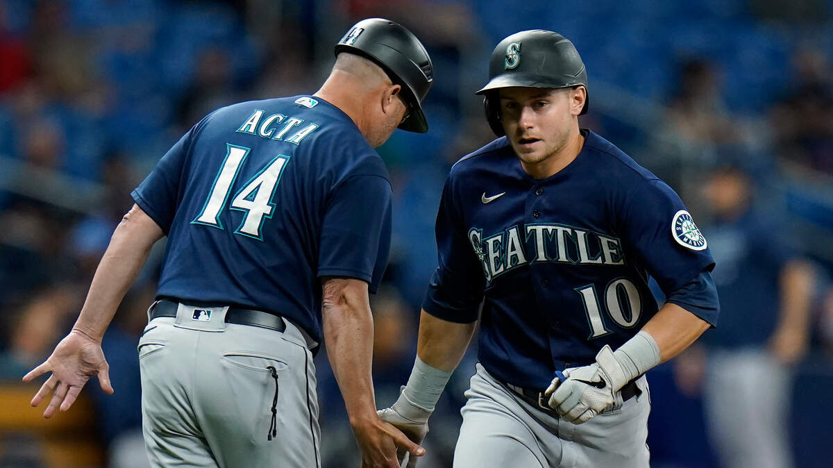 Seattle Mariners’ Jarred Kelenic (10) celebrates with third base coach Manny Acta (14) after his solo home run off Tampa Bay Rays pitcher Luis Patino during the fourth inning of a baseball game Tuesday, Aug. 3, 2021, in St. Petersburg, Fla. (AP Photo/Chris O’Meara)