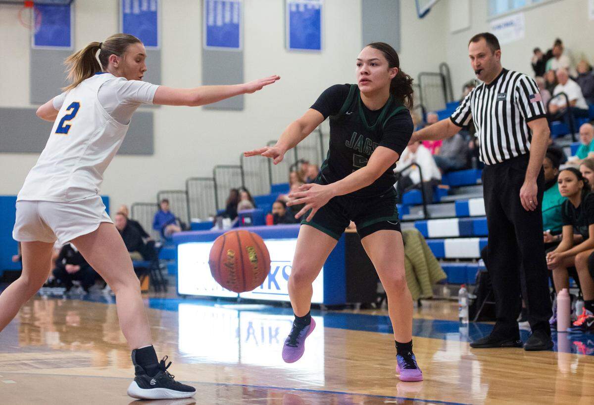 Emerald Ridge guard Monique Carter (5) passes around Tahoma guard Hope Hassmann (2) in the third quarter of a 4A district semifinal game at Curtis High School in University Place, Wash. on Feb. 15, 2023. Tahoma defeated Emerald Ridge 50-45.