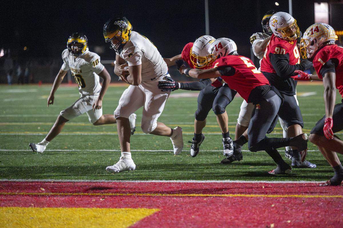 Lincoln running back Jadeon Scranton (2) runs into the end zone for a touchdown with pressure from Mount Tahoma defenders on Saturday, Nov. 22, 2025, in Tacoma, Wash.