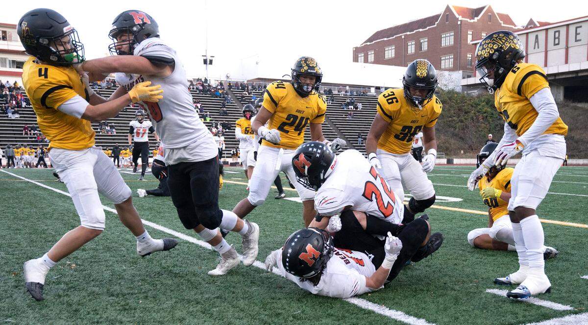The Lincoln Abes and Monroe Bearcats mix it up near the sidelines during Saturday afternoon’s 3A state football playoff game at Lincoln Bowl in Tacoma, Washington, Nov. 12, 2022. Lincoln won the game, 49-16.