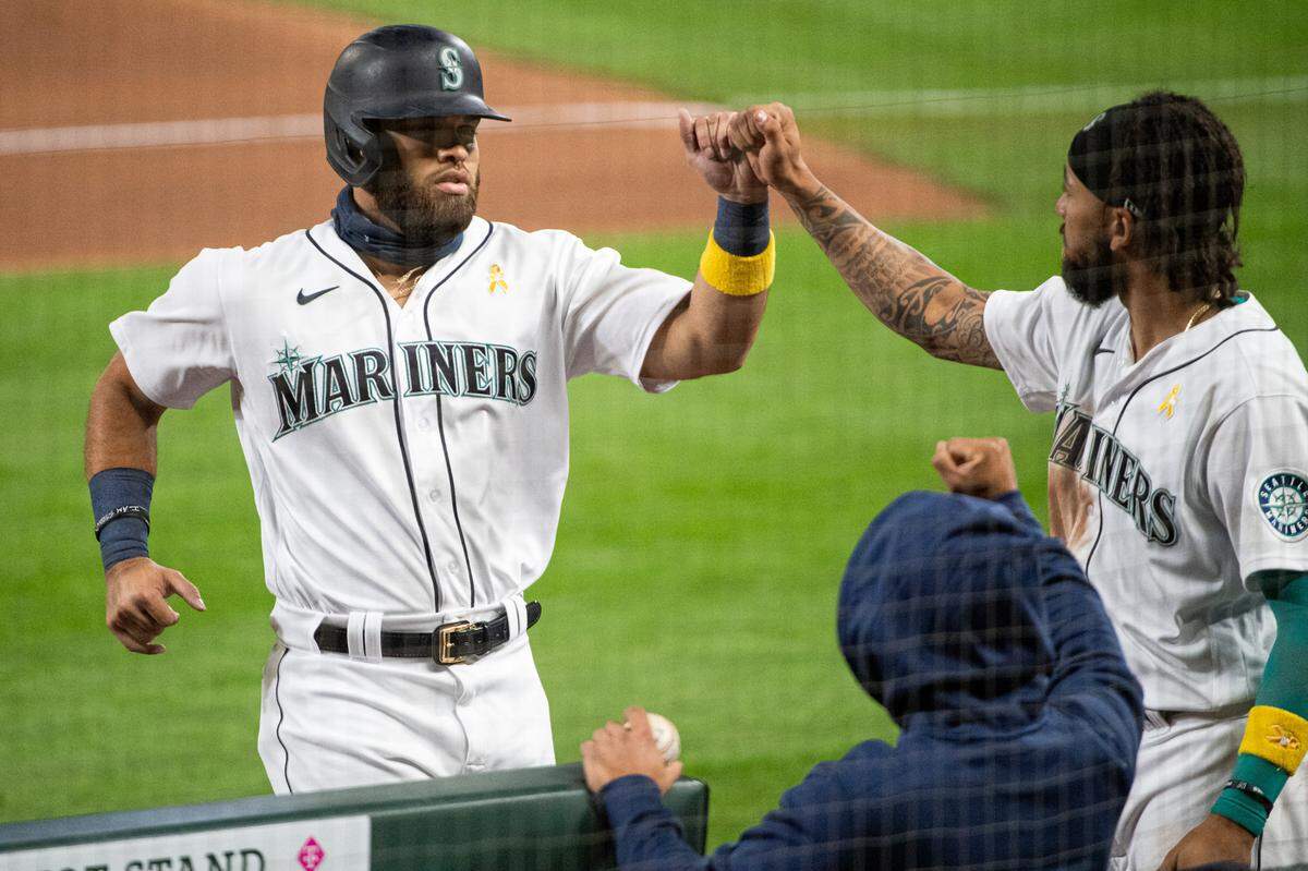 Seattle Mariners first baseman Jose Marmolejos (26) fist bumps Seattle Mariners shortstop J.P. Crawford (3) after his hit to score a run during the eighth inning. The Seattle Mariners played the Texas Rangers in a Major League Baseball game at T-Mobile Park in Seattle, Wash., on Saturday, Sept. 5, 2020.