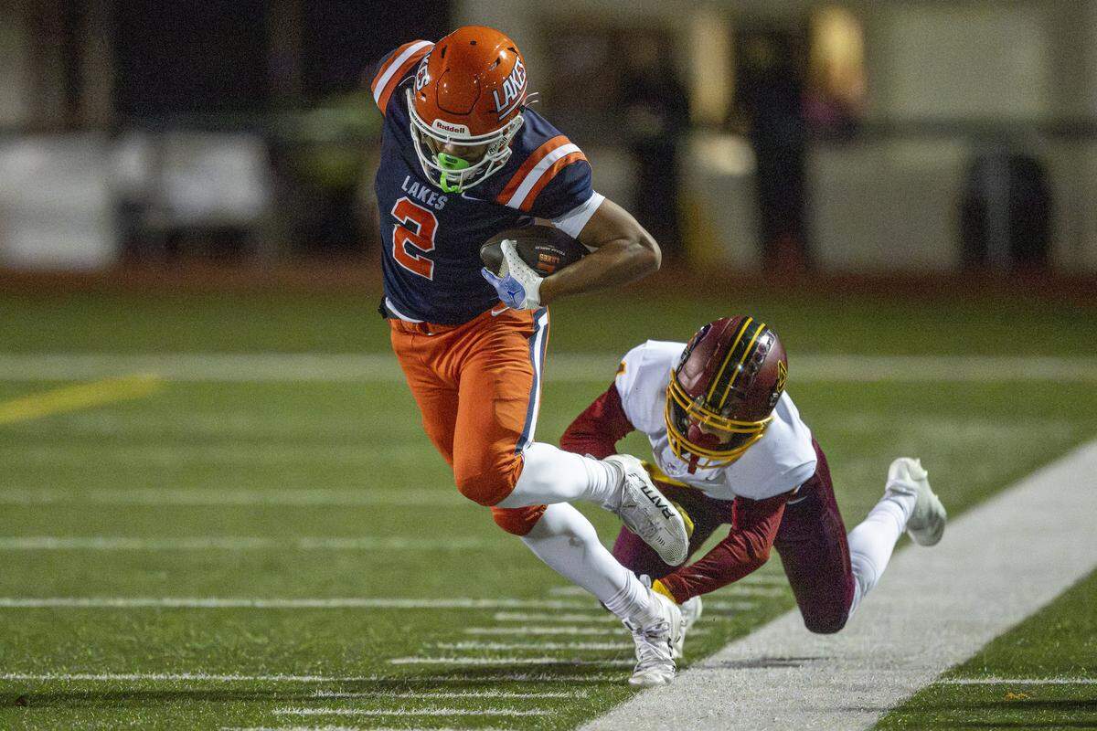 Lakes wide receiver Tristan Baker (2) is pushed out of bounds by Capital cornerback Carter Armstrong (4) on Friday, Oct. 24, 2025, in Lakewood, Wash.