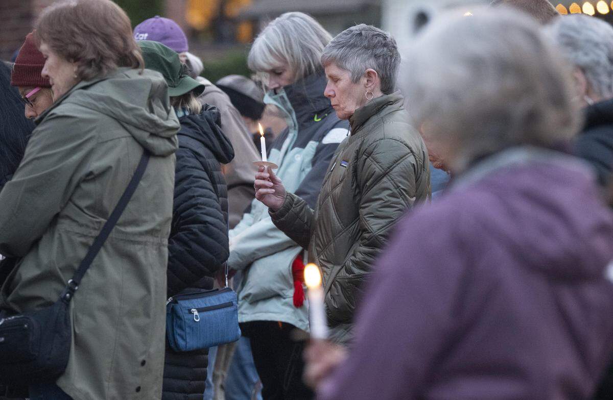 People bow their heads for a moment of silence during a community vigil for the victims of last month's stabbing attack on Wednesday, March 4, 2026, at Skansie Brothers Park in Gig Harbor, Wash.