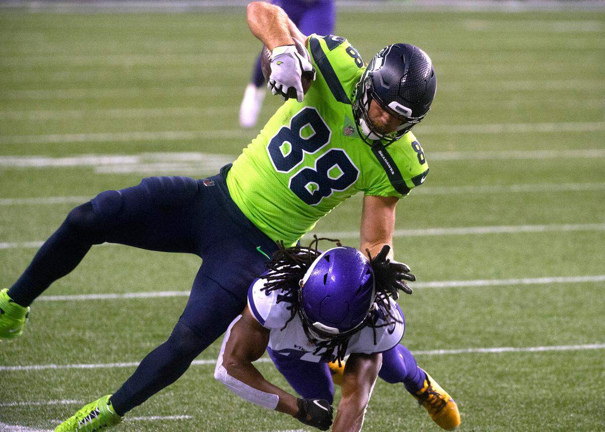 Seattle Seahawks tight end Greg Olsen is upended by Minnesota Vikings safety Anthony Harris during Sunday night’s NFL football game at Centurylink Field in Seattle, Washington, on Sunday, Oct. 11, 2020.