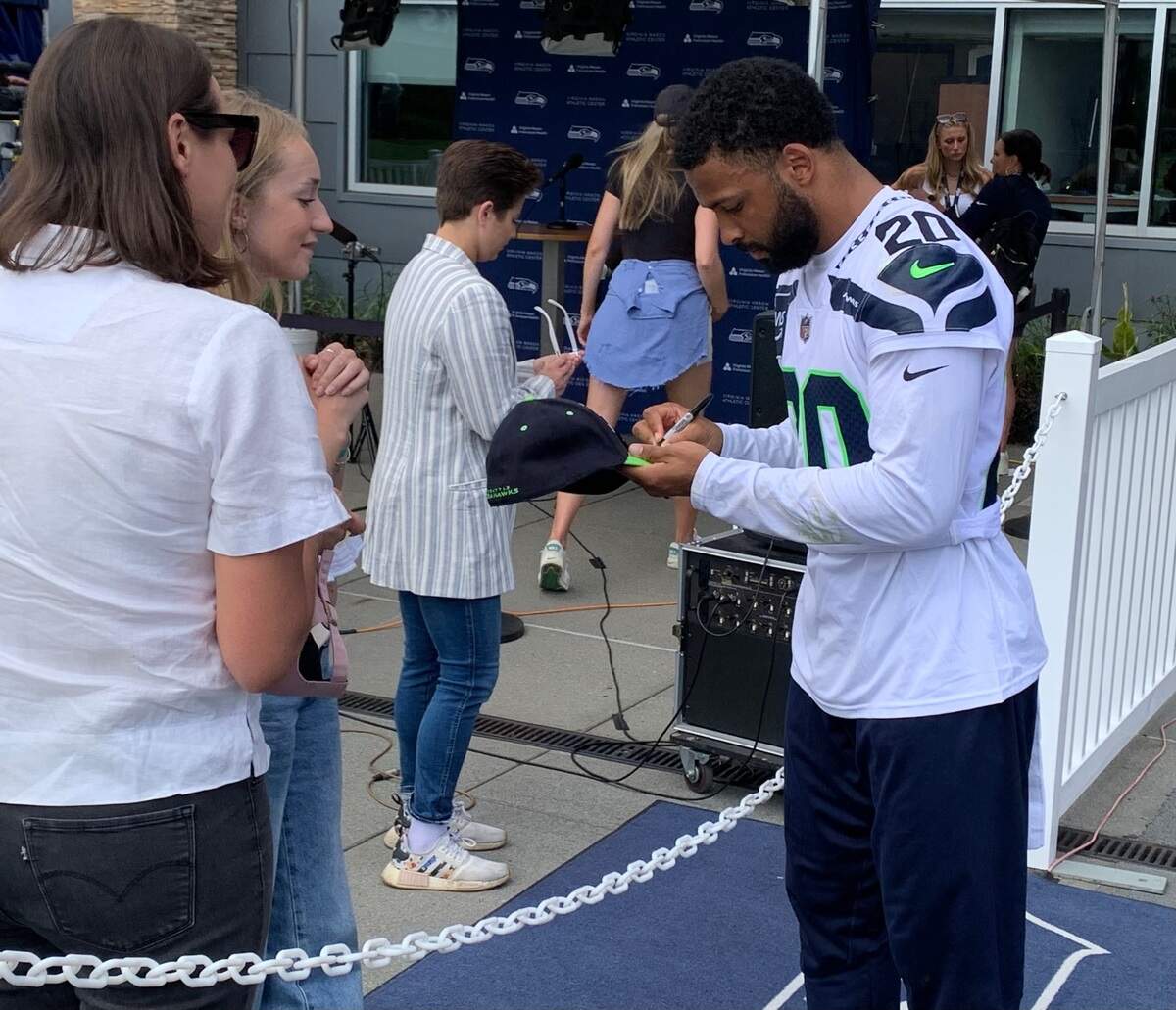 Pro Bowl safety Julian Love (20) signs autographs for fans hours after he signed a three-year contract extension worth up to $36 million on the second day of Seattle Seahawks training camp, July 25, 2024, at the Virginia Mason Athletic Center in Renton.