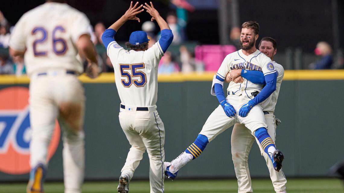Seattle Mariners’ Jesse Winker, front right, is lifted by Ty France as he celebrates a win over Kansas City Royals in 12 innings of a baseball game, Sunday, April 24, 2022, in Seattle. (AP Photo/John Froschauer)